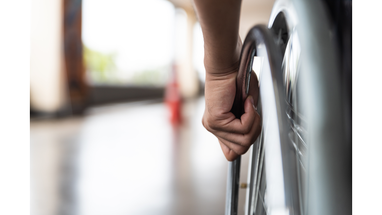 closeup disabled man hand on wheel of wheelchair