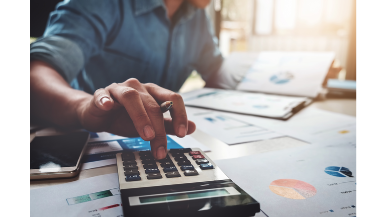Business accounting concept, Business man using calculator with computer laptop, budget and loan paper in office.