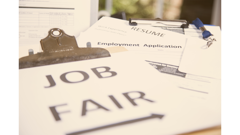 Job fair table with employment applications, resumes.