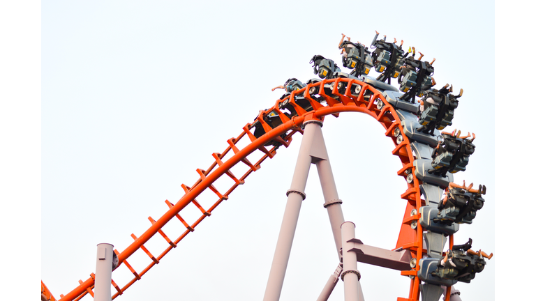 Low Angle View Of People Enjoying Rollercoaster Ride At Amusement Park Against Clear Sky