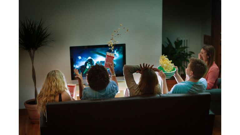 Group of Friends Watching Halloween Scary Movie Together at Home