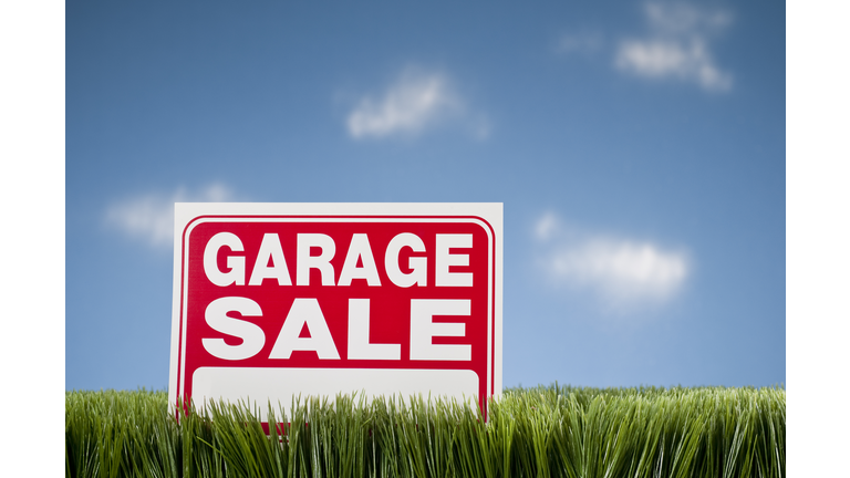Garage Sale Sign In Grass Against Blue Sky