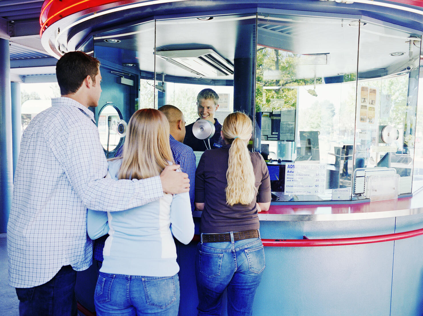 People waiting in line to buy tickets at box office, rear view