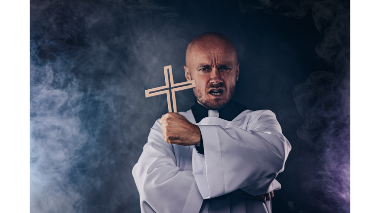 Catholic priest exorcist in white surplice and black shirt