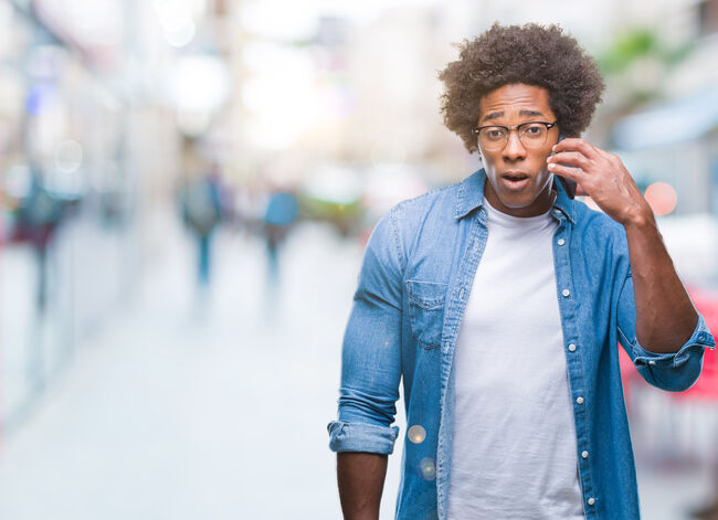 Afro american man talking on the phone over isolated background scared in shock with a surprise face, afraid and excited with fear expression