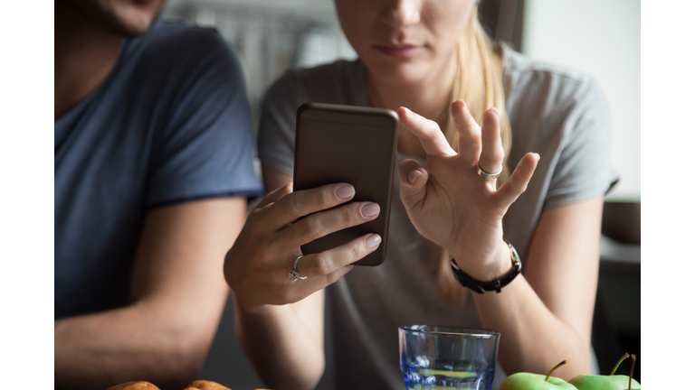 Couple customers holding mobile phone using smartphone apps, close up