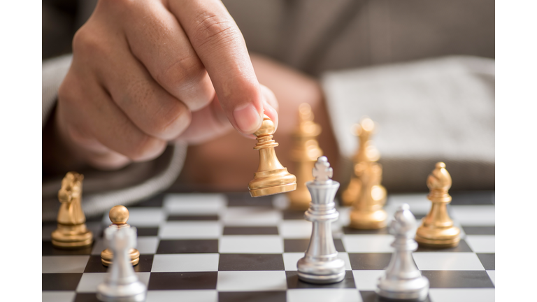 Businessman hand with businessman goal with chess