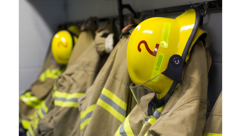 Coats and helmets of fire fighters hanging on hooks