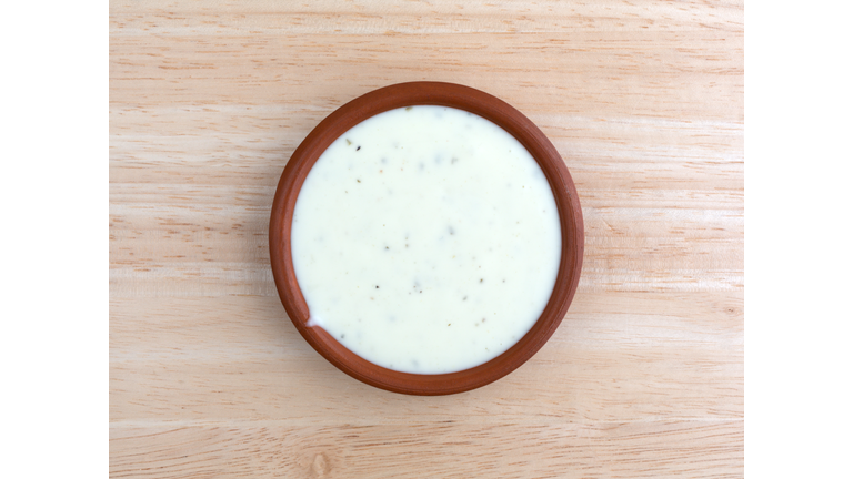 Bowl of ranch dressing on a wood table top view