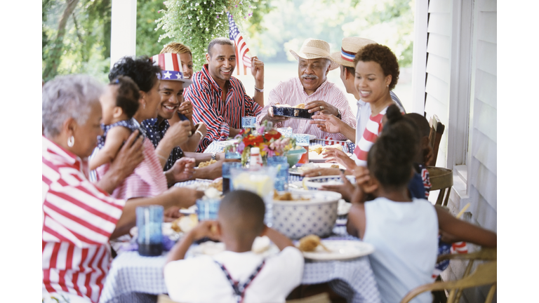 Multi-generation Black family eating at Fourth of July barbecue