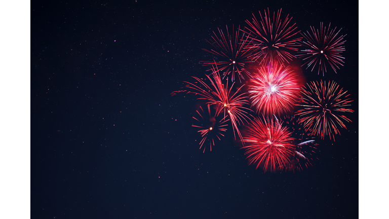 Red  fireworks located right side over night sky