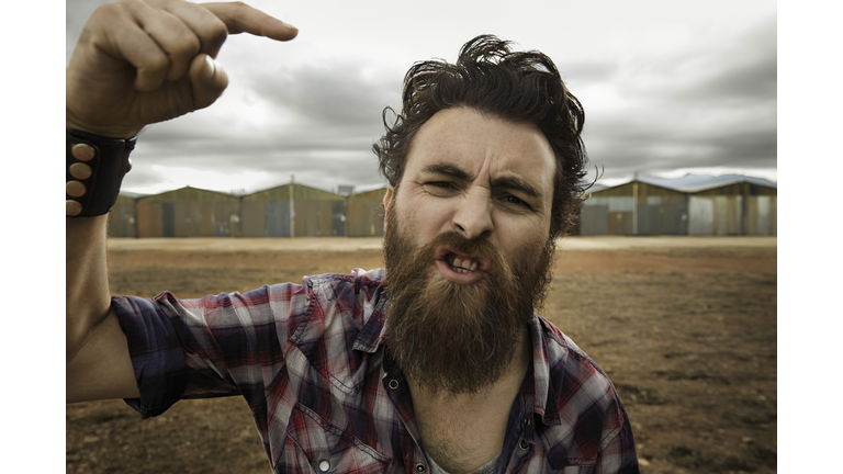 Angry man with full beard shouting at camera