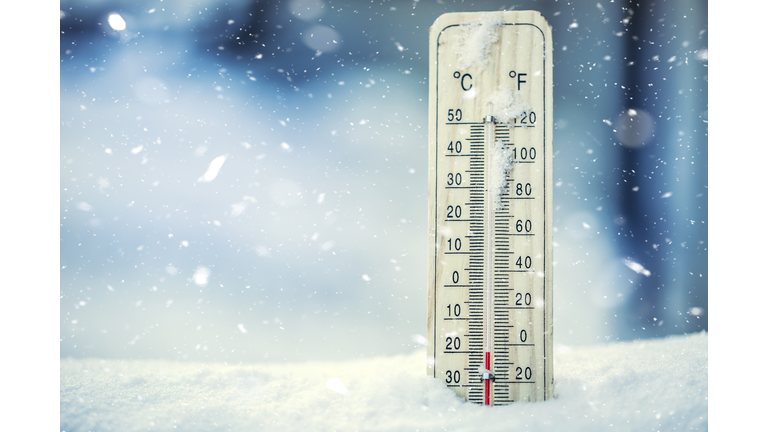 Thermometer on snow shows low temperatures under zero.