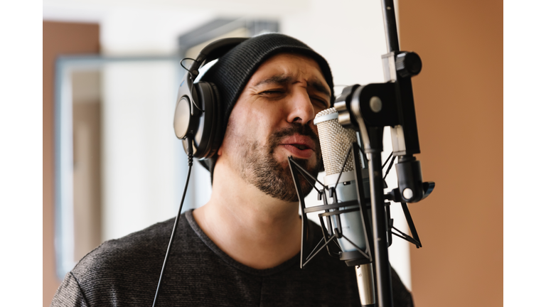 Young man singing with mic.