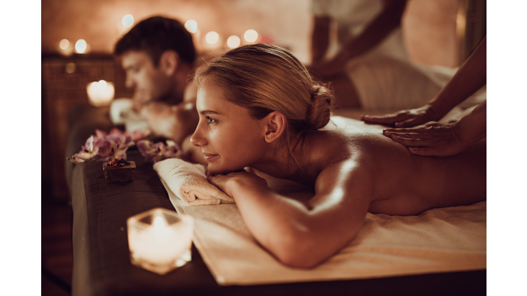 Smiling woman and her boyfriend having back massage at the spa.
