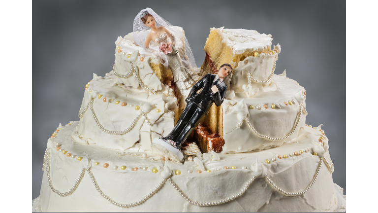 Bride and groom figurines collapsed at ruined wedding cake