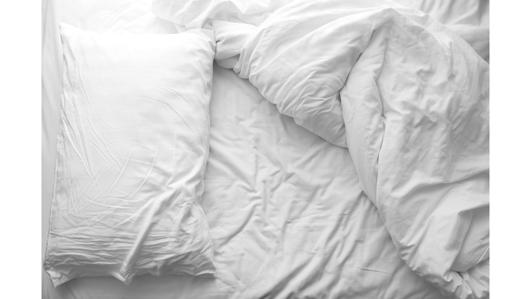 Messy bed. White pillow with blanket on bed unmade. Concept of relaxing after morning.