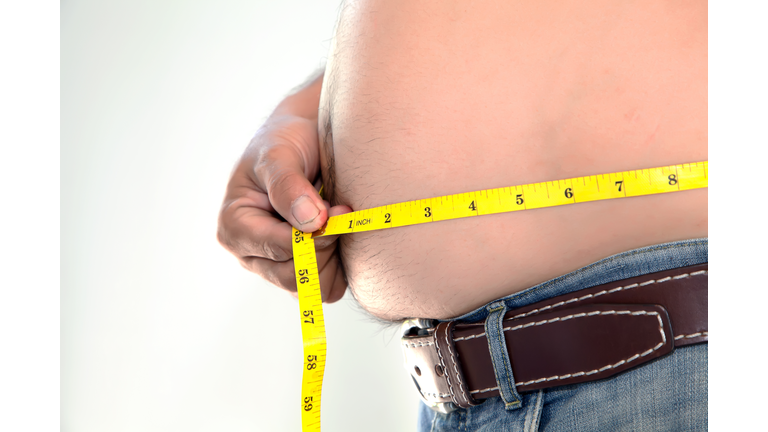 Obese person measuring his belly.