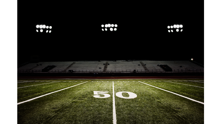 Fifty-yard line of football field at night