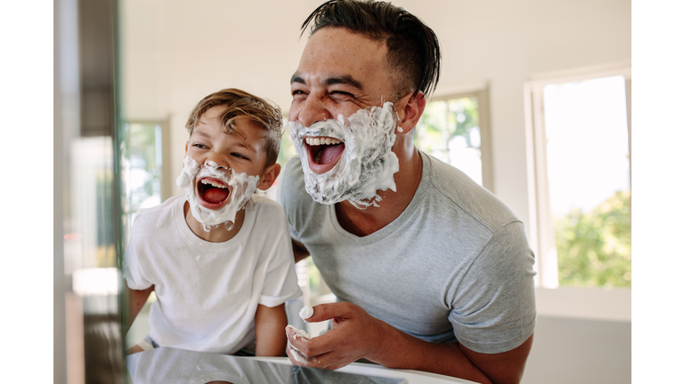 Father and son having fun while shaving in bathroom