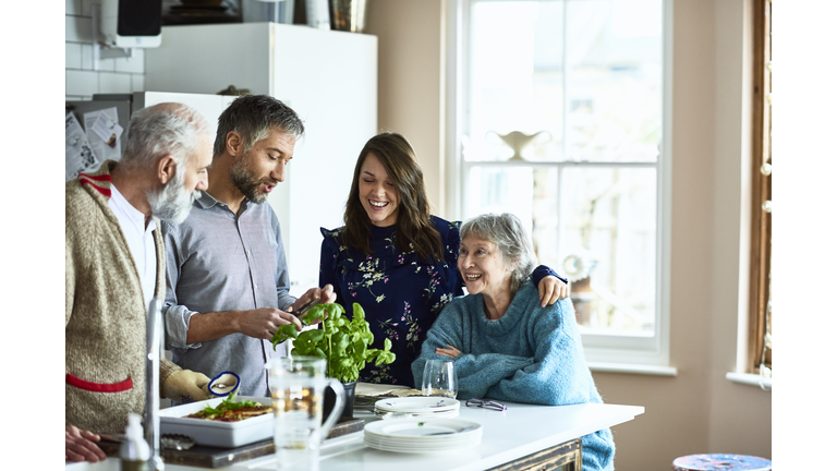 Couple hosting their parents and in laws for dinner in family home