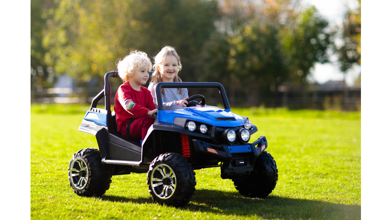 Kids driving electric toy car. Outdoor toys.