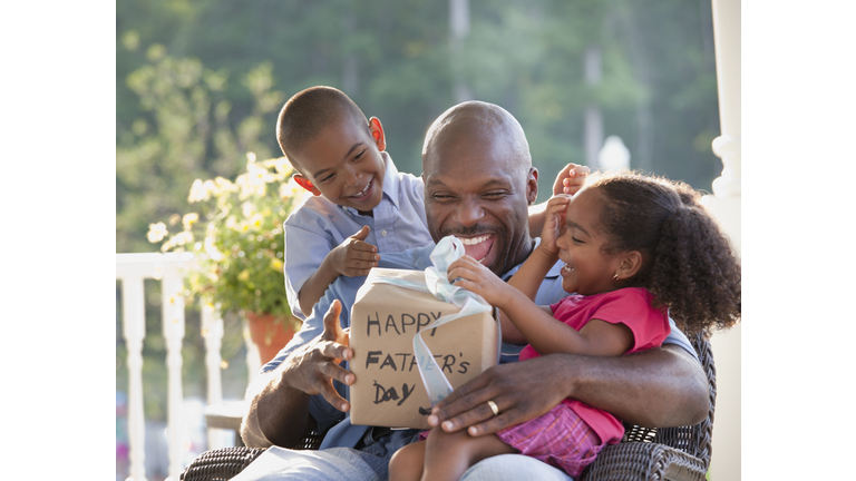 Boy and girl watching father open Father's Day gift