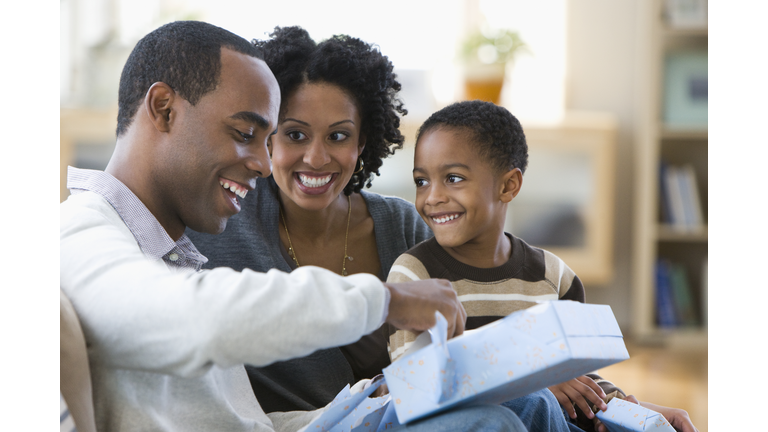 African American man opening gift from family