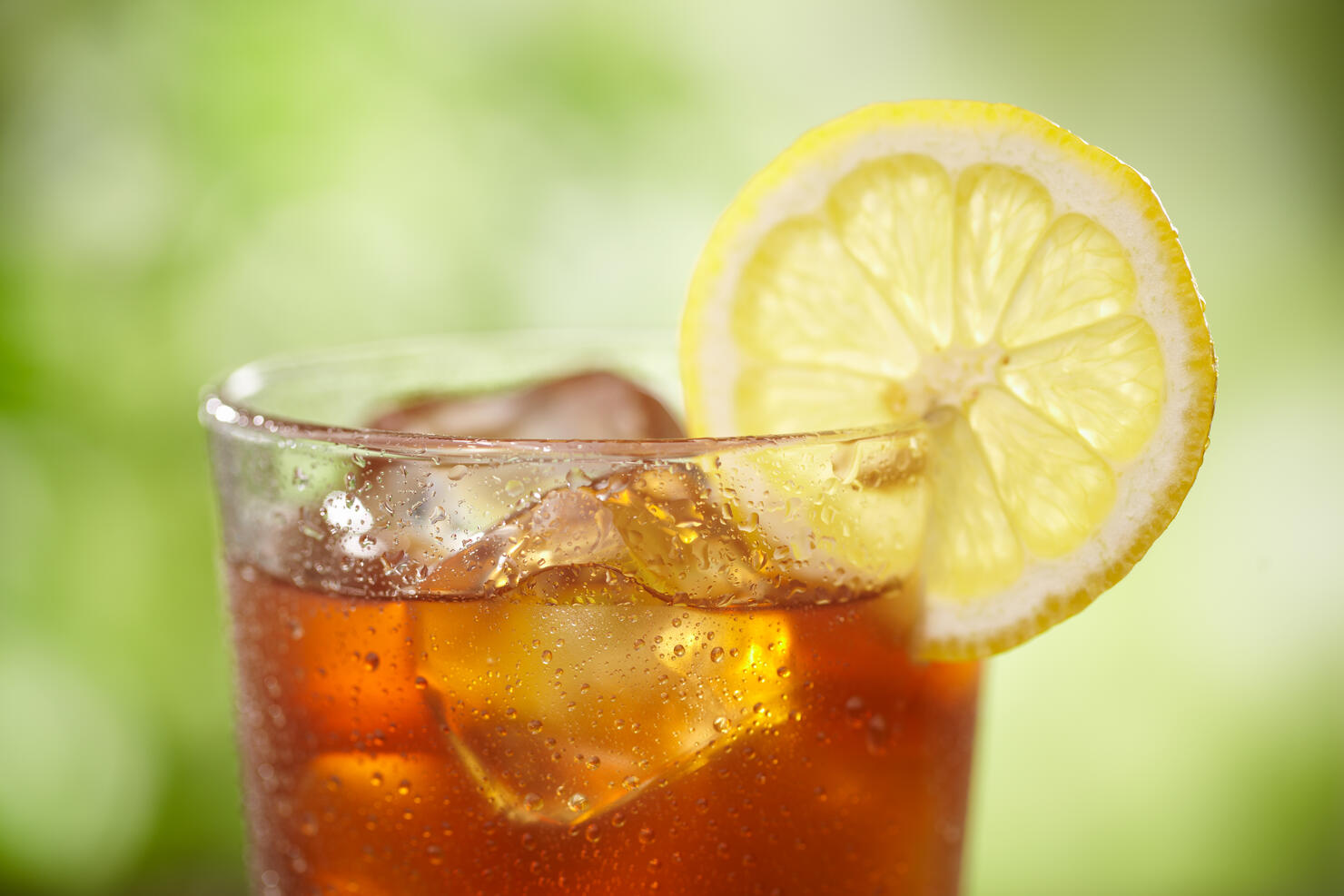 A close-up of a glass of iced tea with lemon