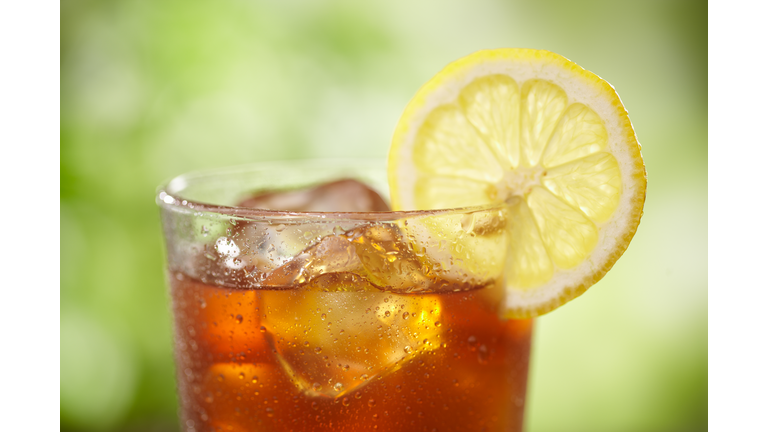 A close-up of a glass of iced tea with lemon