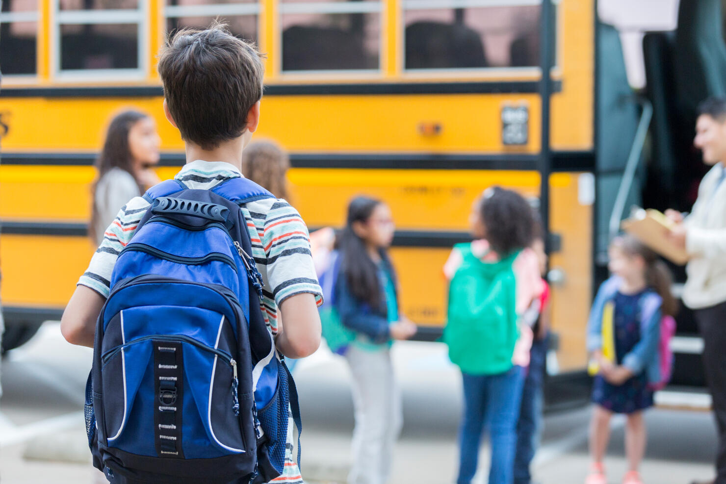 Young boy waits to load school bus