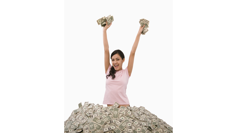 Hispanic woman standing in pile of money