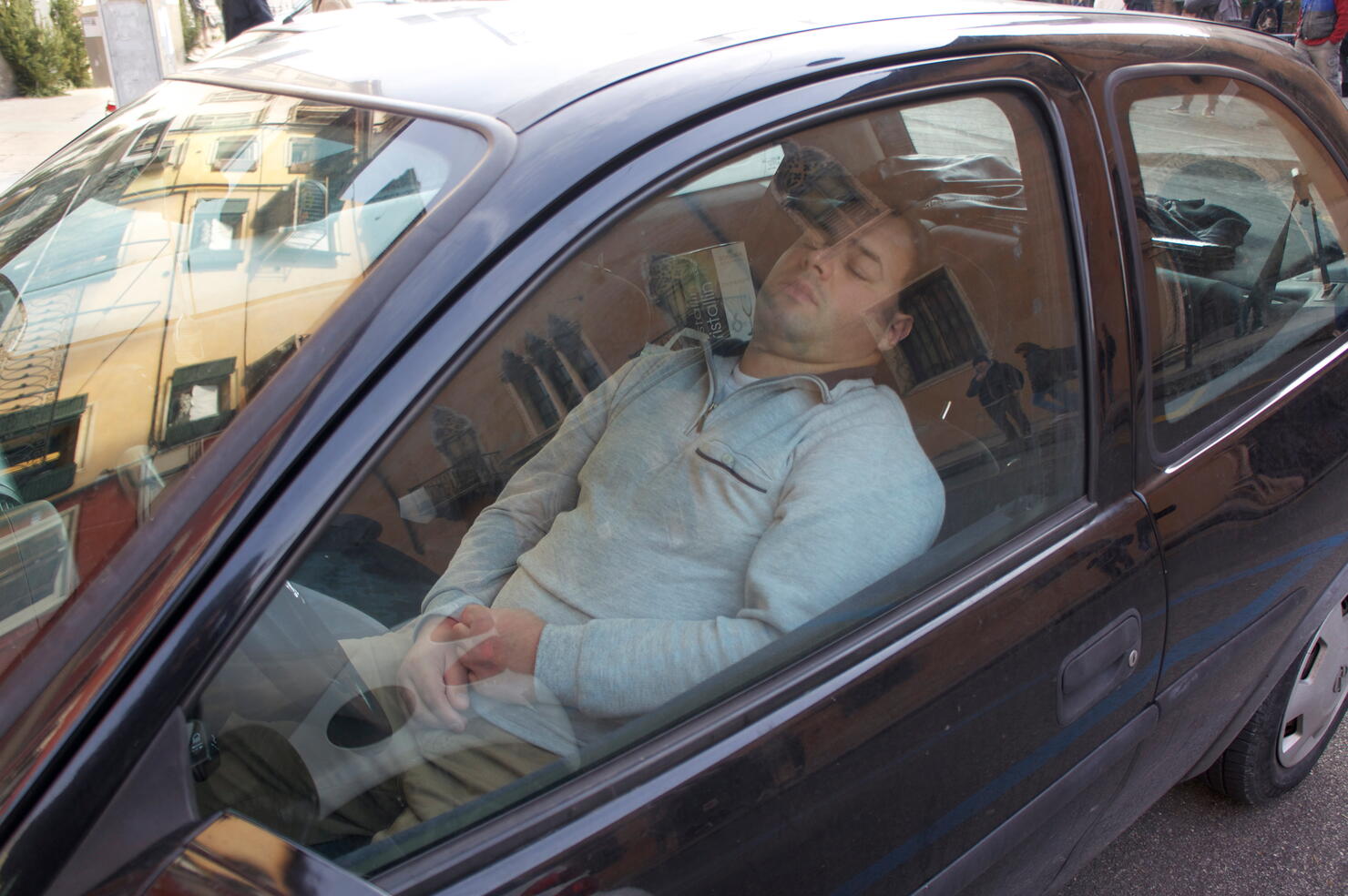 Man Sleeping In Car Seen Through Window