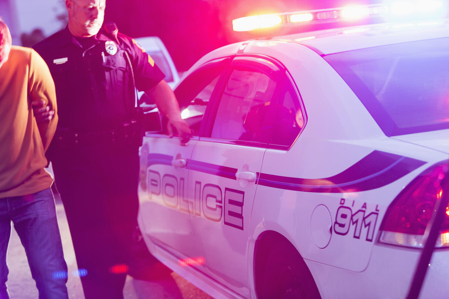 Police officer arresting a young man at night