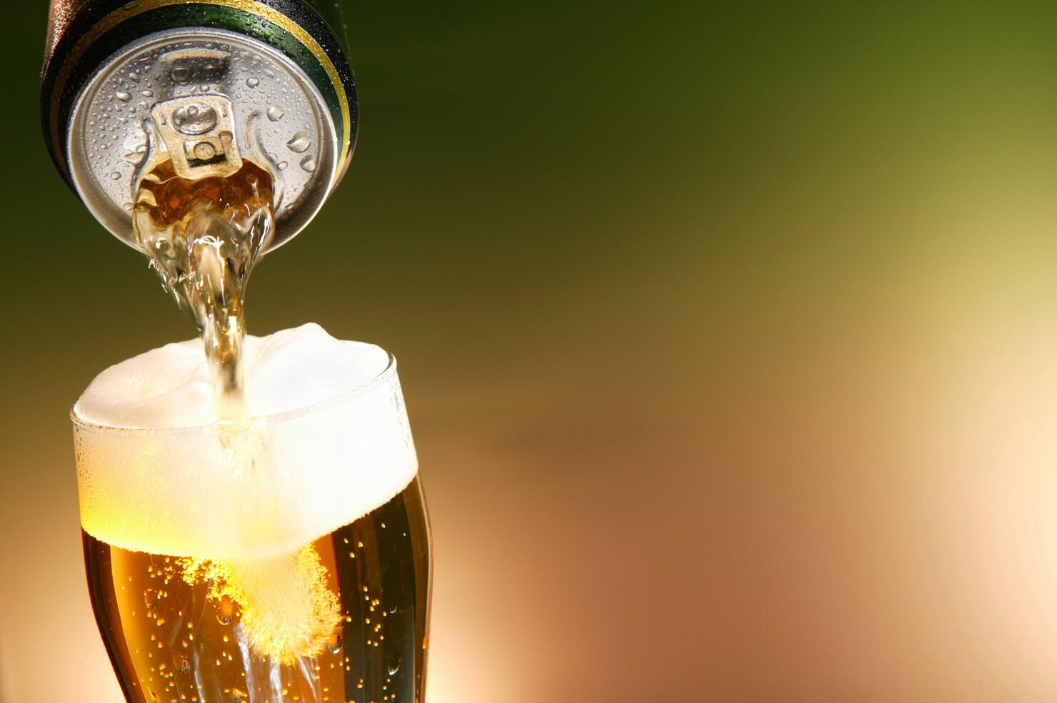 Beer being poured from a can into a glass
