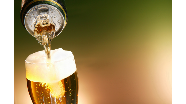 Beer being poured from a can into a glass