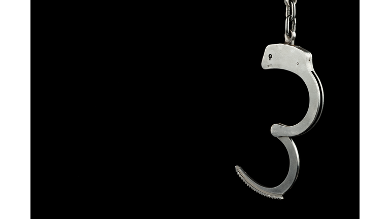 Open handcuffs on a black background