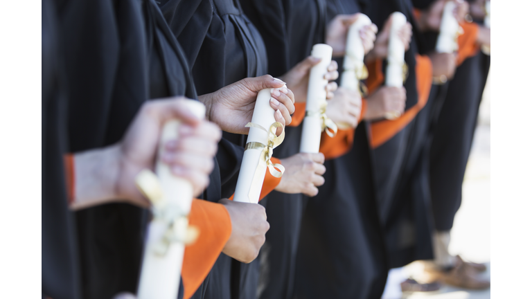 Multi-ethnic teenage graduates in cap and gown