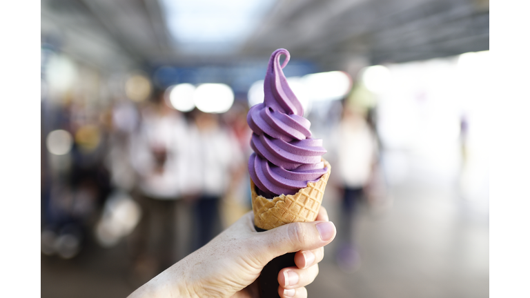 hand holding a yam soft serve ice cream cone outdoors