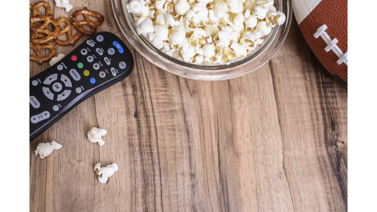 Watching the football game with snacks, drinks.