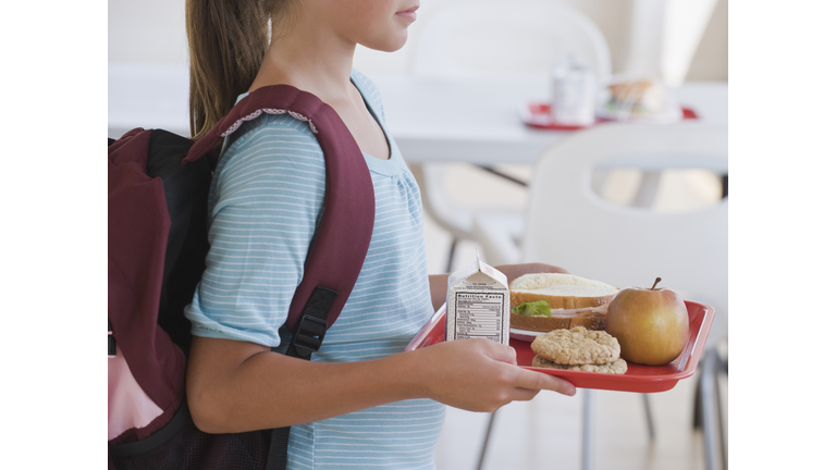 Girl carrying lunch tray at school