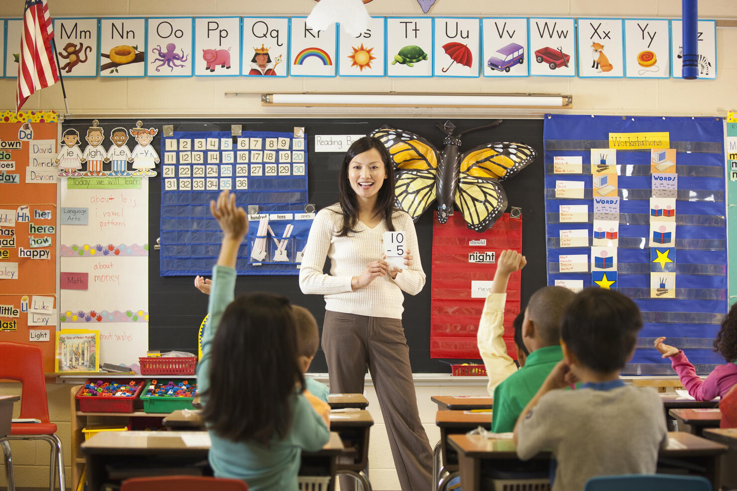 Asian teacher teaching math to students in classroom