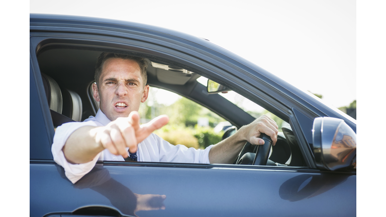 Angry Caucasian businessman shouting out car window