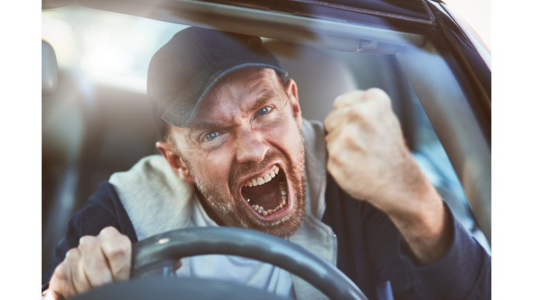 Enraged man shaking fist through windscreen: road rage