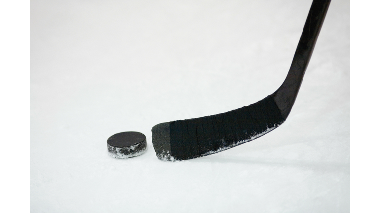 Close-up of an ice hockey stick with a hockey puck