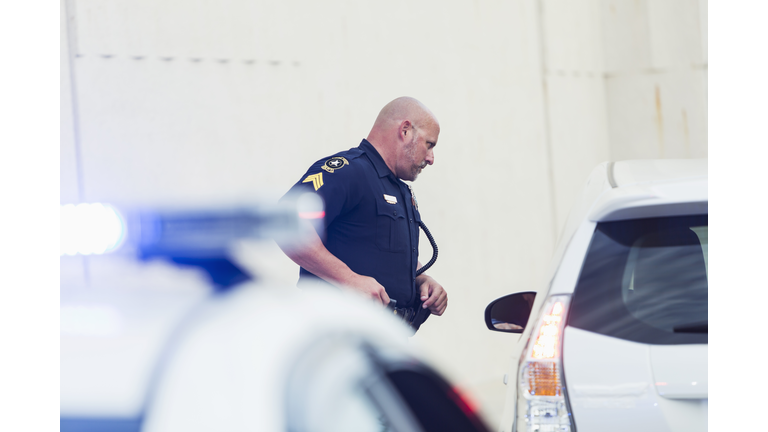 Police officer talking to driver of car he pulled over