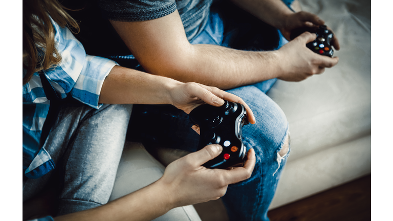 Midsection Of People Holding Video Game Controller At Home