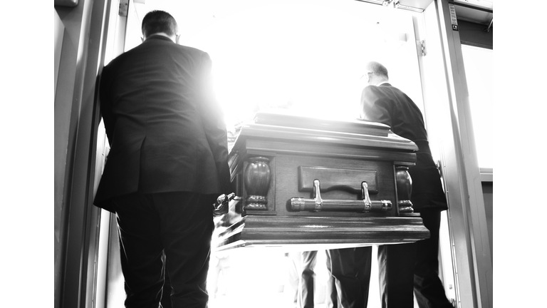 Rear View Of People Carrying Coffin