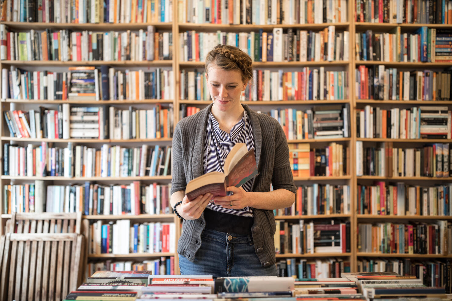Beautiful young female customer reading book at bookstore