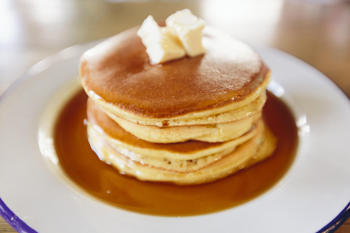 Close up of stack of American pancakes with butter and maple syrup